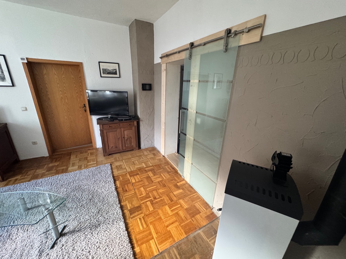 Living room with TV, wooden dresser and glass sliding door